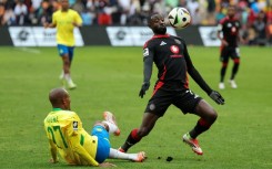 Deon Hotto (R) controls the ball watched by fallen Khuliso Mudau of Mamelodi Sundowns during a South African Premiership match in Johannesburg on March 16, 2025.
