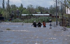 Rescuers wade through floodwaters following a heavy storm that hit the Argentinian port city of Bahia Blanca