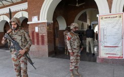 Paramilitary soldiers stand guard at a railway station in Sibi district after separatists attacked a train in the mountainous region and took passengers hostage
