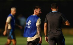 Lionel Messi (C) talks with Argentina head coach Lionel Scaloni (R) 
