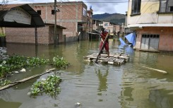 Rafael Quispe steers a makeshift raft through what used to be the streets of his village in western Bolivia