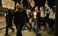 Supporters of impeached South Korean President Yoon Suk Yeol shout at protesters against him as they march past each other on a street
