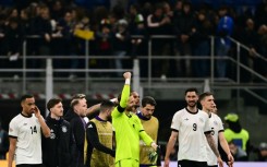 Germany goalkeeper Oliver Baumann celebrates with team-mates after winning the Nations League quarter-final first leg against Italy in Milan