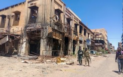 Fighters loyal to the army patrol a market area in Khartoum