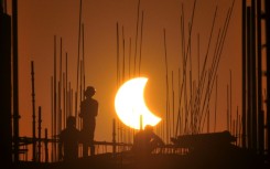Workers at a construction site in India during 2022's partial solar eclipse