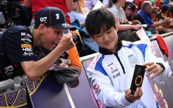Man in demand: Yuki Tsunoda takes selfies with fans at the season-opening Australian Grand Prix