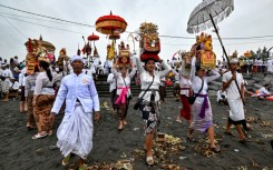 Hindu devotees take offerings to a beach near Denpasar