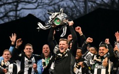 Newcastle manager Eddie Howe lifts the League Cup in front of a crowd of 150,000 celebrating fans