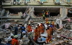 Rescue teams work to reach people believed trapped under the rubble of the collapsed building Sky Villa Condominium in Mandalay