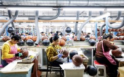 Employees produce basketballs that will be exported to Europe at a factory in Sihong, in eastern China's Jiangsu province on March 25, 2025.