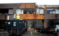 People remove debris from a building destroyed by a tornado in Louisville, Kentucky
