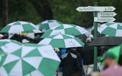 Spectators evacuate Augusta National Golf Club after bad weather halted the first official practice round for the 89th Masters