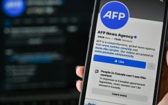 This illustration photo taken on April 14, 2025, in Montreal, Canada, shows the alert: “People in Canada can’t see this content” on the Facebook page of news organization Agence France-Presse (AFP)