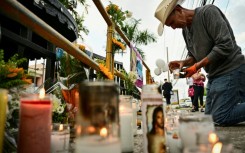 A man lights a candle in tribute to victims of the Jet Set nightclub roof collapse in Santo Domingo