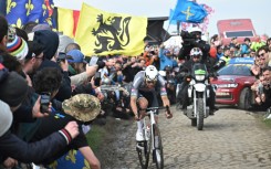 A liquid is spilled as Mathieu van der Poel battles past on the cobbles of Paris-Roubaix