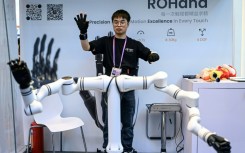 An exhibitor controls robot hands from ROhand at the Canton Fair in Guangzhou, in southern China's Guangdong province