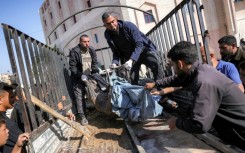 People transport from the bed of a truck the remains of a victim killed in Israeli bombardment on Jabalia, northern Gaza