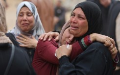 Palestinians mourn during a funeral of relatives killed in an Israeli strike on a school-turned-shelter at the Al-Shifa hospital in Gaza City