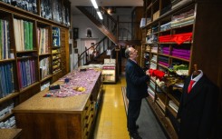The shop's shelves are heavy with colourful bolts of fabric.