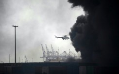 A helicopter flies above Shahid Rajaee port following the huge explosion