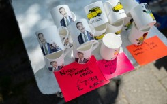 Mugs bearing the image of Reform UK party leader Nigel Farage are displayed on a stall on a street market in Frodsham, near Runcorn, northwest England, where Reform has been pushing hard to oust Labour and win a parliamentary by-election