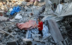 A man stands on the rubble of a building hit in an Israeli strike in the Bureij camp for Palestinian refugees in the central Gaza Strip