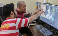 Ryan Adriandhy Halim (L), speaking with a computer illustrator in Jakarta