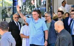 Brazilian former president Jair Bolsonaro waves to supporters as he leaves hospital on May 4, 2025, three weeks after undergoing surgery to treat an intestinal obstruction