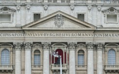 A worker prepares the main central balcony of St Peter's basilica