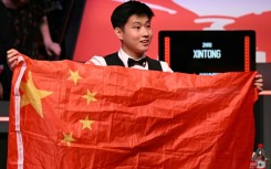 Zhao Xintong poses with the Chinese flag after winning the World Snooker Championship final