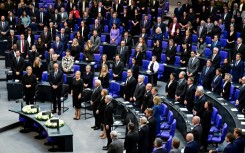 Attendees sing the national anthem at a commemoration ceremony marking 80 years since the defeat of Nazi Germany