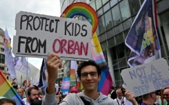 A protester holds a sign reading 'Protect the children from Orban' during a demonstration in Brussels, May 17, 2025.