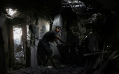 A Palestinian man searches the rubble of a house hit in Israeli strikes on the northern Gaza Strip