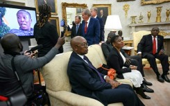 A video is played as South African President Cyril Ramaphosa (R) looks on during a meeting with US President Donald Trump in the Oval Office of the White House in Washington, DC, on May 21, 2025. South African President Cyril Ramaphosa meets Donald Trump on Wednesday amid tensions over Washington's resettlement of white Afrikaners that the US president claims are the victims of "genocide."