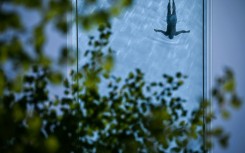 A person swims in the Sky Pool, a transparent acrylic swimming pool bridge in London, as the Met Office reports the UK has had its sunniest spring since records began with 630 hours of sunshine between March 1 and May 27