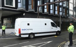 A prison van passes police officers outside Liverpool Magistrates' Court as a 53-year-old former Marine was due to appear for the first time facing seven charges of driving into crowds of football fans