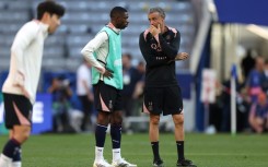 Paris Saint-Germain coach Luis Enrique (R) speaks to Ousmane Dembele on the pitch at Munich's Allianz Arena on Friday