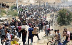 People carry boxes of relief supplies from the Gaza Humanitarian Foundation at adistribution center in the central Gaza Strip