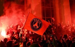 Jubilant Paris Saint-Germain supporters set off flares on Place Trocadero in front of the Eiffel Tower