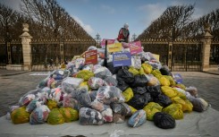 Dustbin bags full of clothes lie outside France's Senate in a March protest