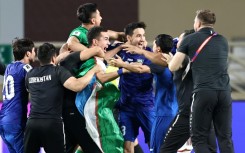Uzbekistan's players celebrate after booking their berth in the FIFA World Cup for the first time with a draw against the United Arab Emirates in Abu Dhabi