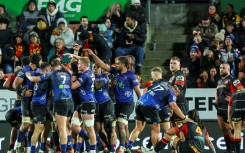 Auckland Blues players celebrate after beating the Waikato Chiefs
