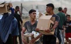 Palestinians carry food aid from the Gaza Humanitarian Foundation
