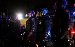 Law enforcement officers stand guard as they face off with demonstrators during a protest following federal immigration operations, in the Compton neighborhood of Los Angeles, California early on June 8, 2025