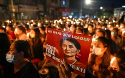 A protester holds a poster of Aung San Suu Kyi during a candlelight vigil to honour those who have died during demonstrations against the military coup in Yangon on March 13, 2021