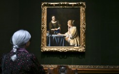 A woman views 'Mistress and Maid' by Johannes Vermeer at the Frick Collection in New York