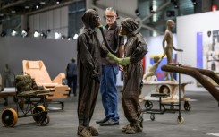An Art Basel visitor has a close look at part of 'The Voyage -- A March To Utopia', by Atelier Van Lieshout