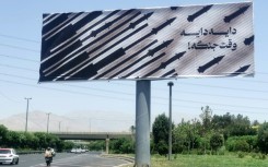 Commuters drive past an anti-Israel billboard in Tehran
