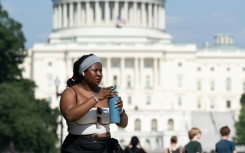 Extreme heat has scorched US cities like the capital Washington, where a woman on the National Mall is seen trying to stay comfortable in the summer weather