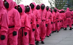 Fans gathered near Seoul's Gyeongbokgung Palace, led by marchers dressed in the bright pink uniforms worn by the show's mysterious masked agents